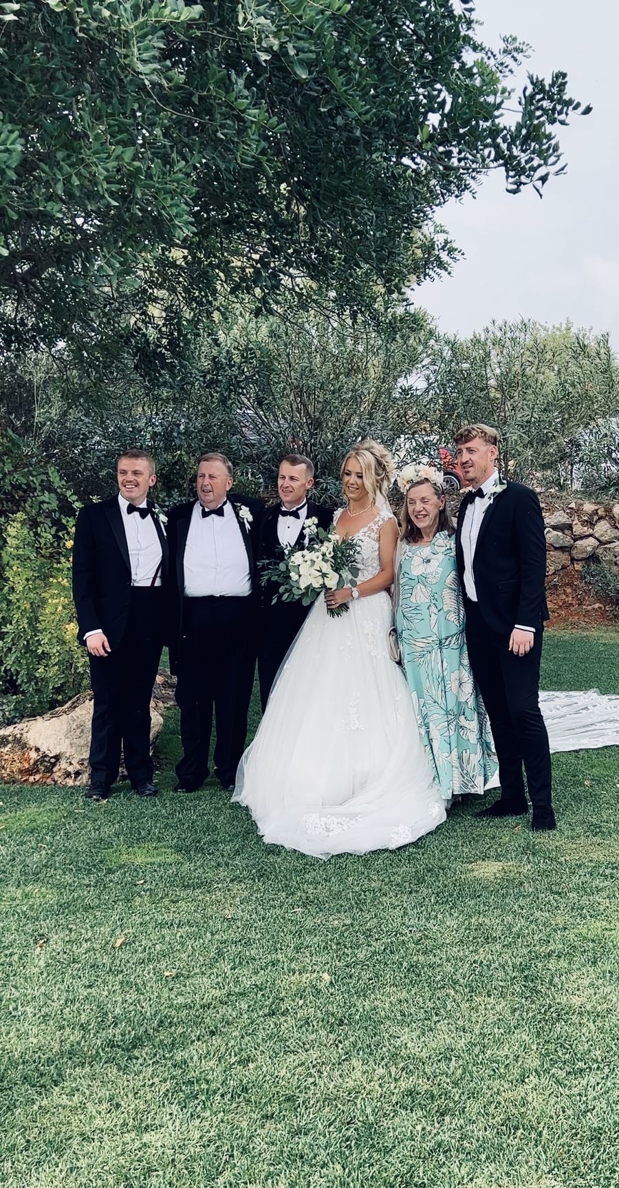Bride and groom with family on a lawn after the ceremony